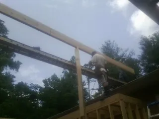 Carpenter setting a ridge beam over a new addition frame — Ice Dam Removal by Roofing Brothers in Westmoreland City