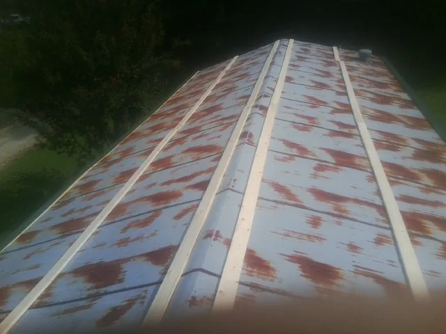 Rusted metal roof panels with new wood purlins before replacement — Storm Damage Roof Repair in Westmoreland City by Roofing Brothers