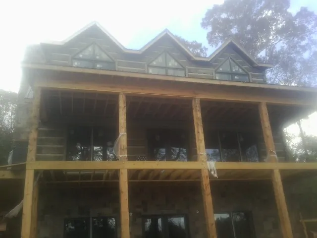 Dormers and porch framing on a large log home under construction — Roof Coating work by our crew in Westmoreland City