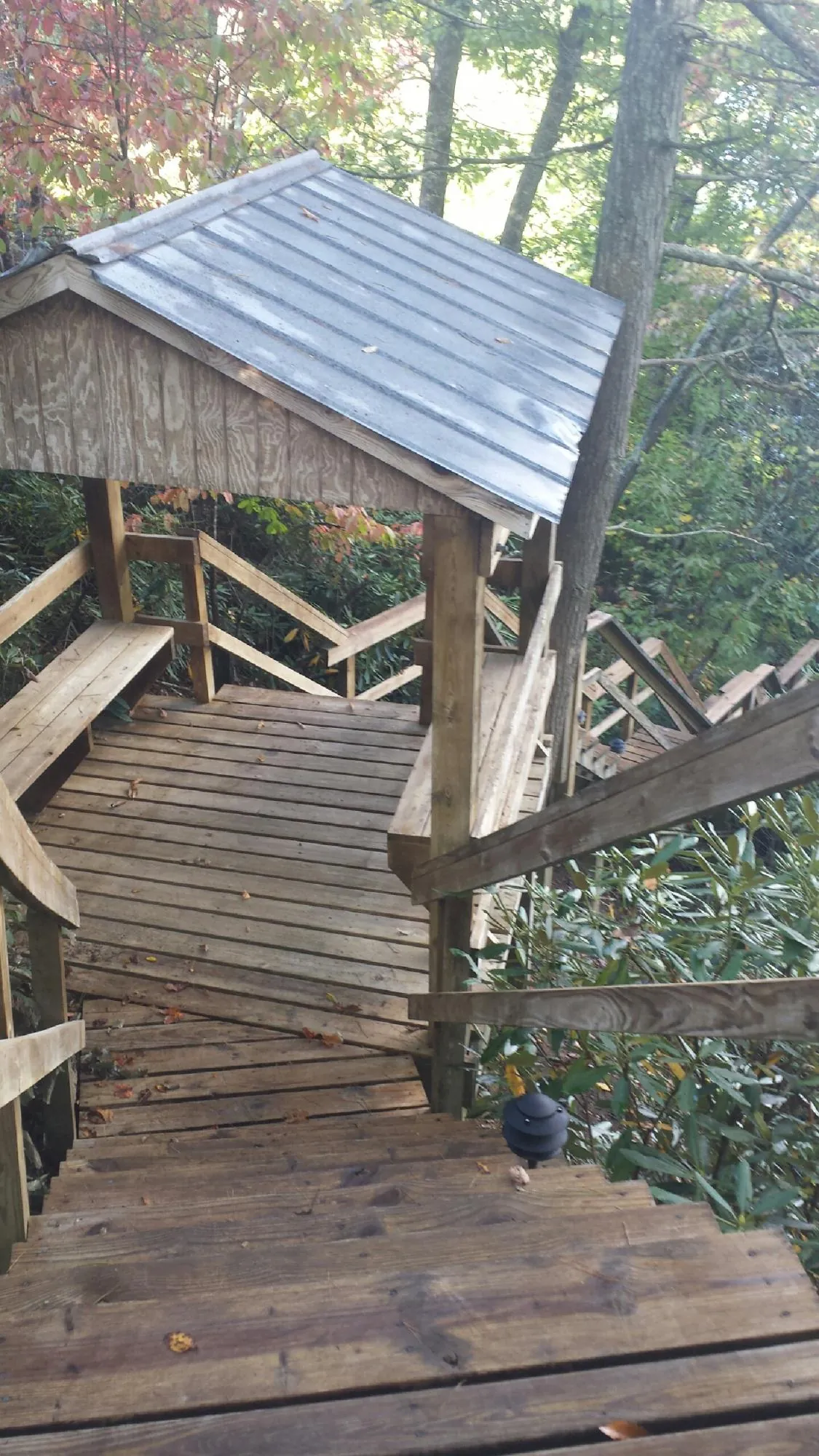 Metal roofed shelter over wooden steps on a wooded walkway — Skylight Repair & Installation work by our crew in Westmoreland City