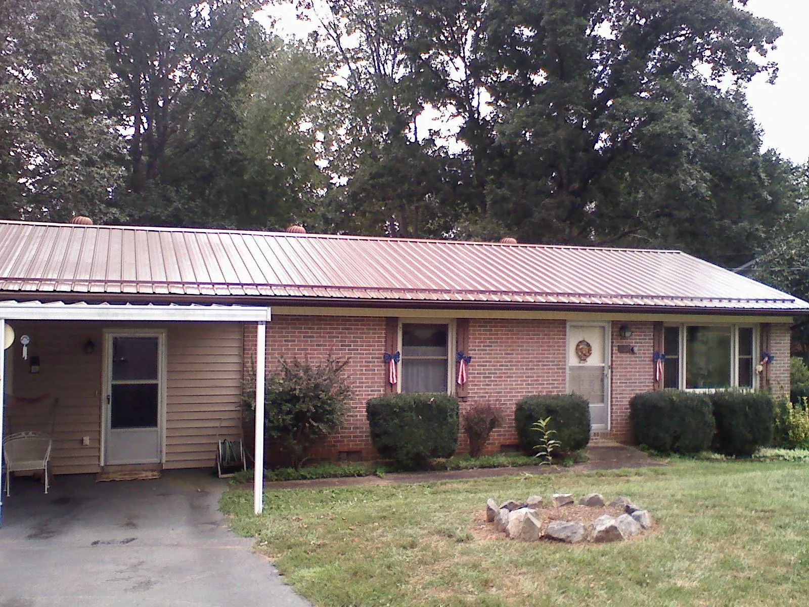 Bronze metal roof and carport on a brick ranch home — Roof Repair work by our crew in Westmoreland City